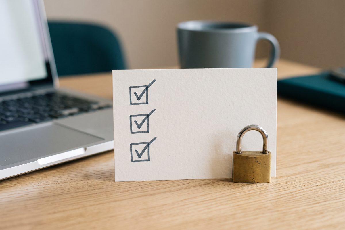 An index card with three ticked checkboxes and a small padlock, standing in for domain authentication steps