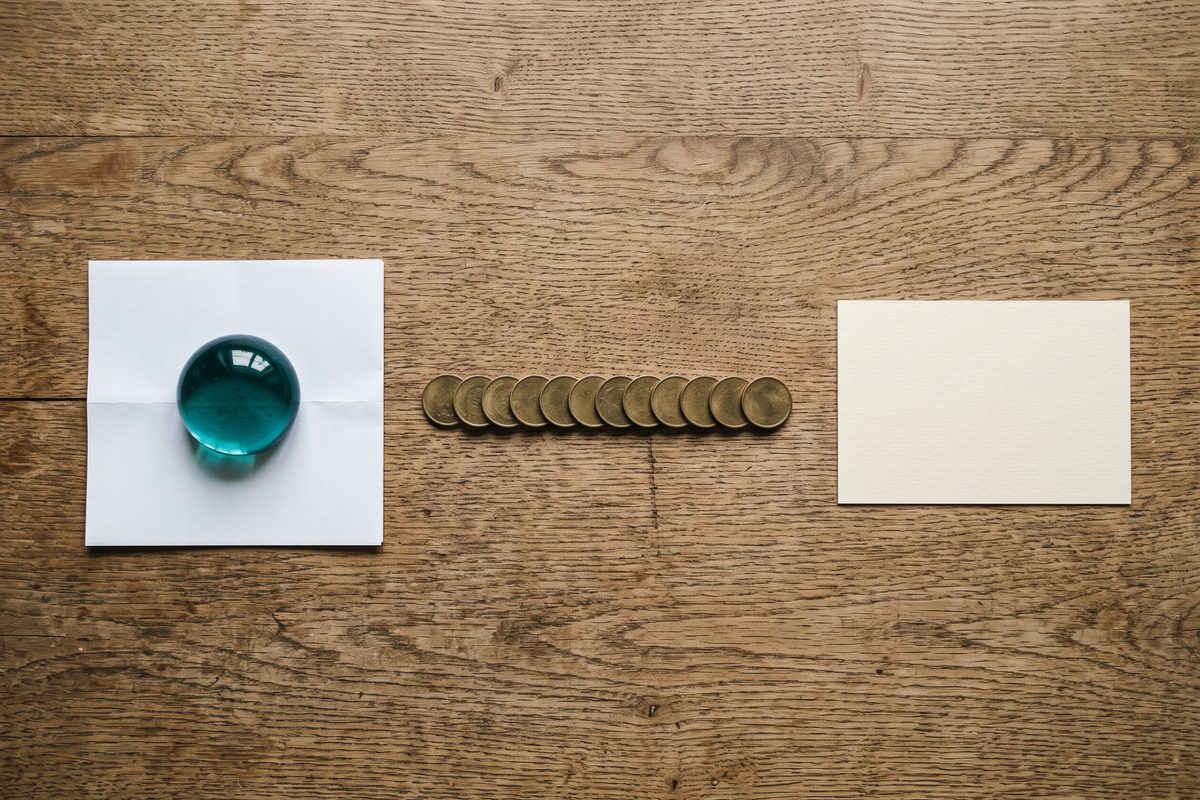 Three objects on a desk representing a one-time purchase, a monthly subscription, and a free option
