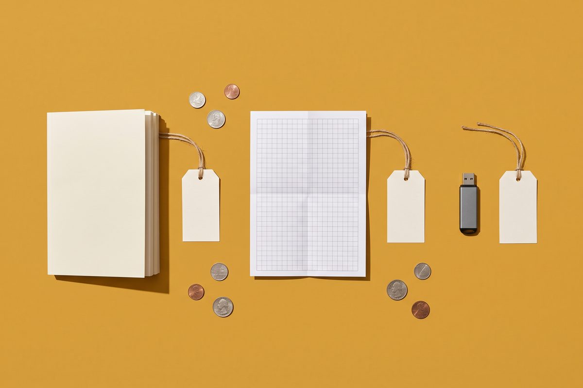 Flat-lay of an ebook, a printed template and a USB stick with blank price tags on a mustard background.